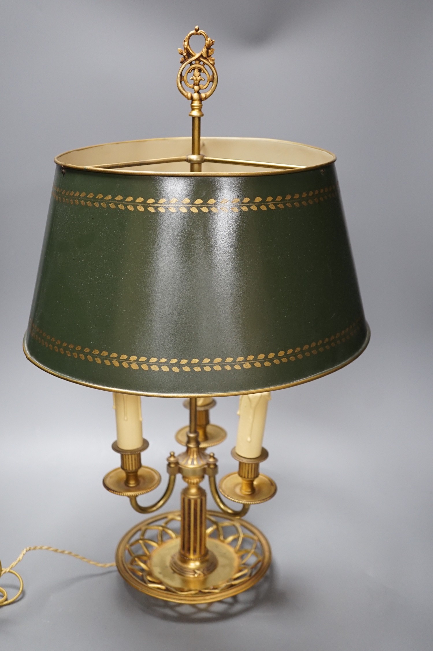 A gilt brass bouillote lamp with tole ware shade, 57 cms high